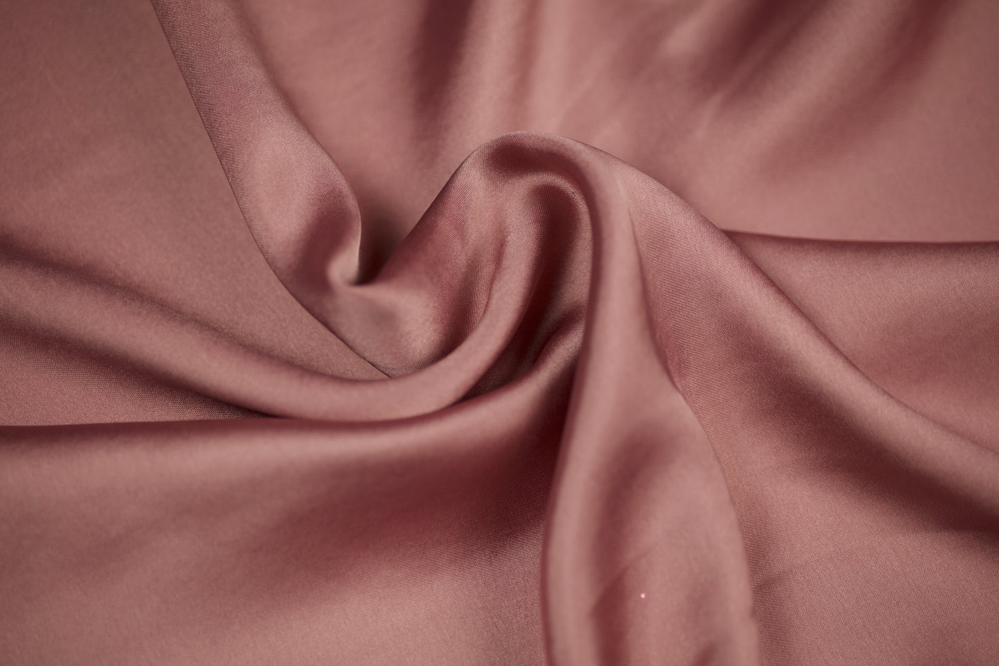 Nahaufnahme eines luxuriösen Satinstoffs in roséfarbenem Altrosa mit edlem Glanz und weichem Faltenwurf – perfekt für elegante Nähideen.