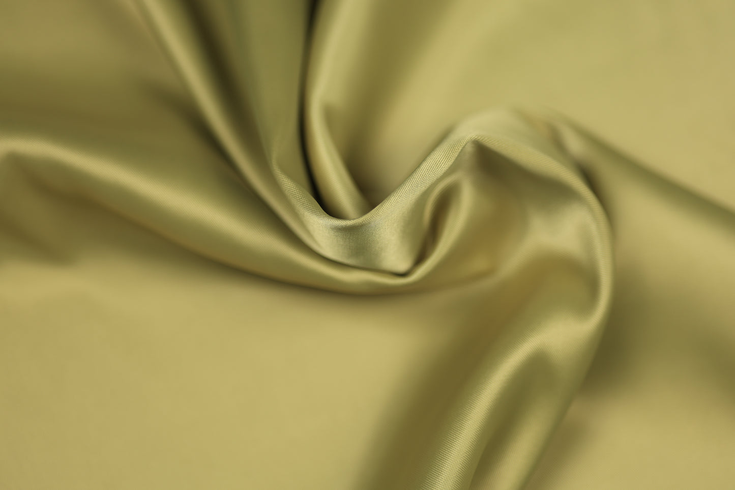 Satinstoff in edlem Helloliv mit weicher Drapierung und seidig glänzender Oberfläche – ideal für Sommerkleider, Accessoires und stilvolle Dekorationen