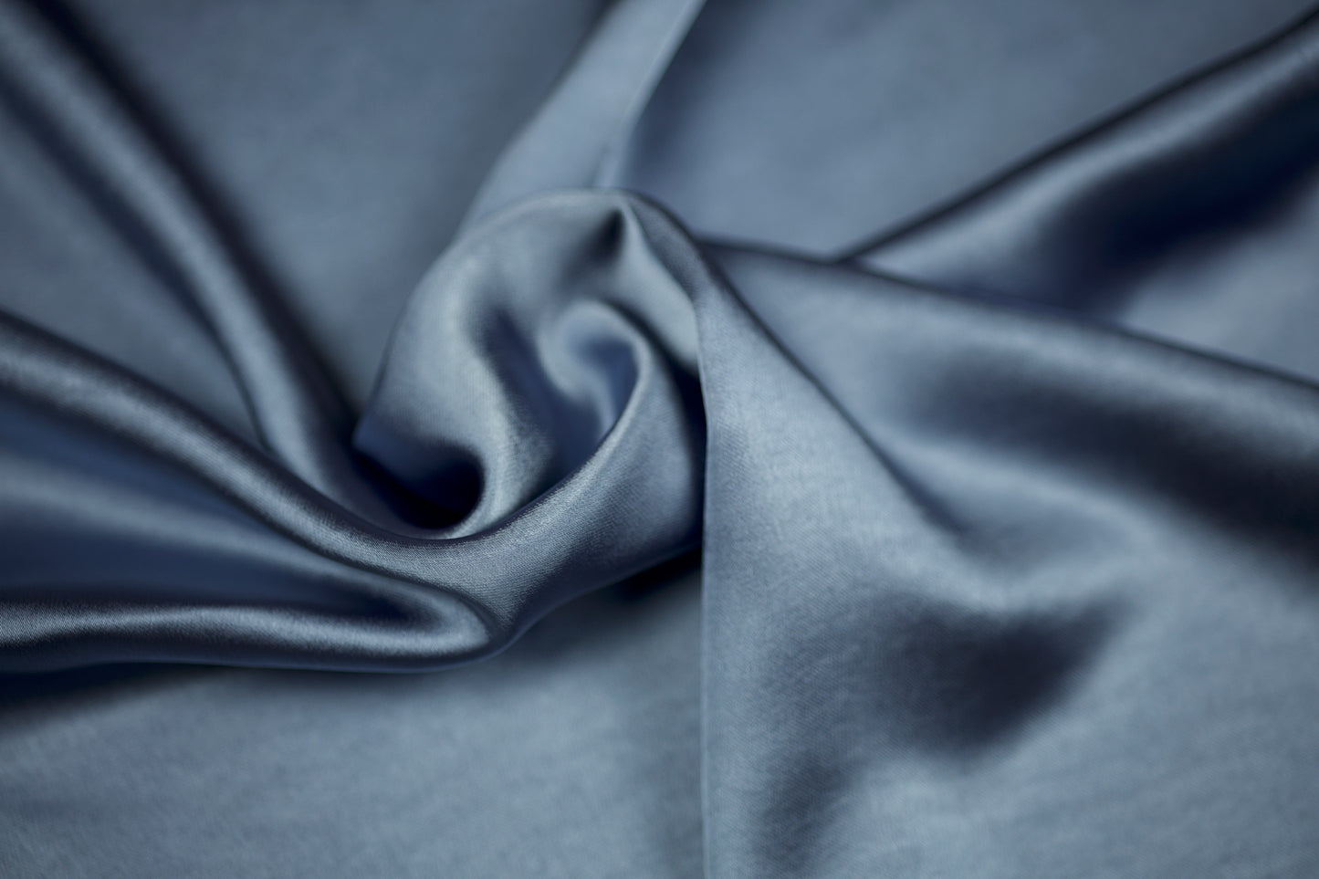 Luxuriöser Satinstoff in Taubenblau mit sanftem Glanz und geschwungener Drapierung – detailreiche Nahaufnahme
