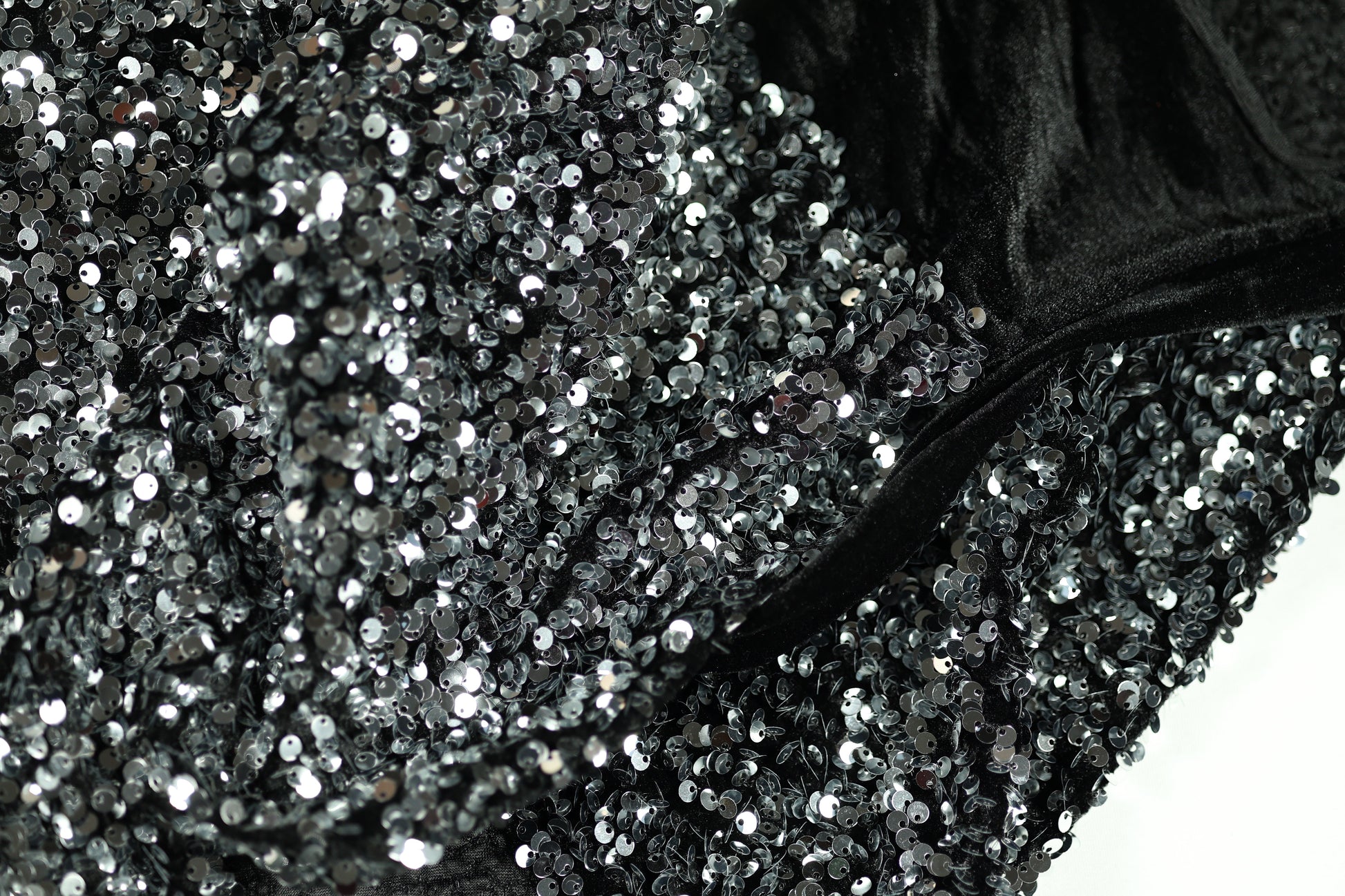 Glänzender Paillettenstoff in Silber auf schwarzem Samt – ideal für Abendmode
