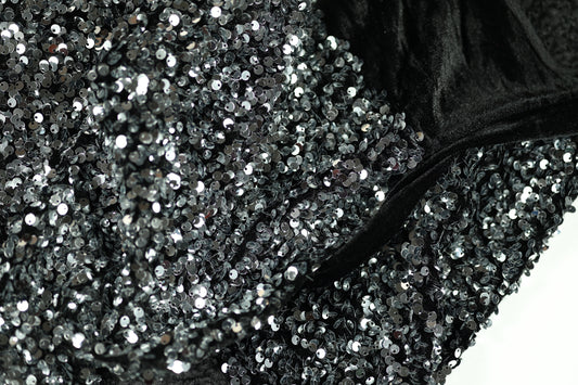 Glänzender Paillettenstoff in Silber auf schwarzem Samt – ideal für Abendmode