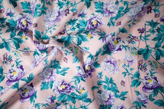 Viskosestoff – Pfingstrosen in Lavendel auf Rosa Hintergrund – Viskosestoff mit Blumenmuster – weich und ideal für sommerliche Kleidung – Stoffstruktur im Nahaufnahme