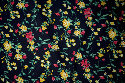 Viskosestoff mit gelben Wildblumen auf nachtblauem Grund