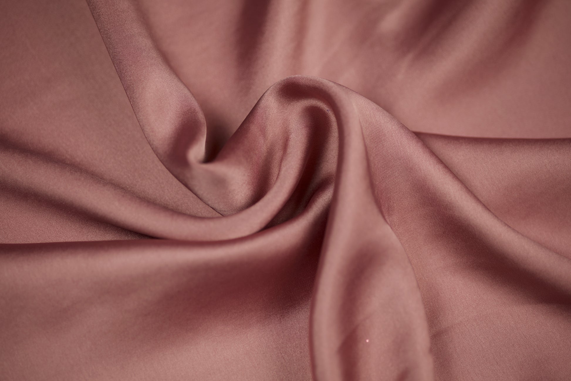 Nahaufnahme eines luxuriösen Satinstoffs in roséfarbenem Altrosa mit edlem Glanz und weichem Faltenwurf – perfekt für elegante Nähideen.